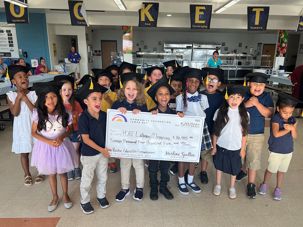Grade school students holding a giant check